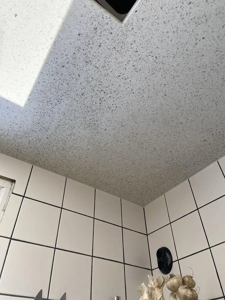 Vit terrazzobänkskiva i Terrazzo Carrara med urtag för underlimmad diskho i ett kök i Lund.