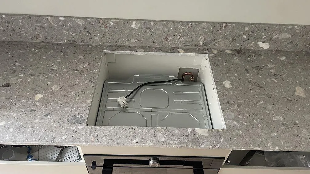 Matt köksbänkskiva i Terrazzo Fior Di Pesco med rektangulär öppning i bänkraden och stänkkant i ett kök i Malmö.