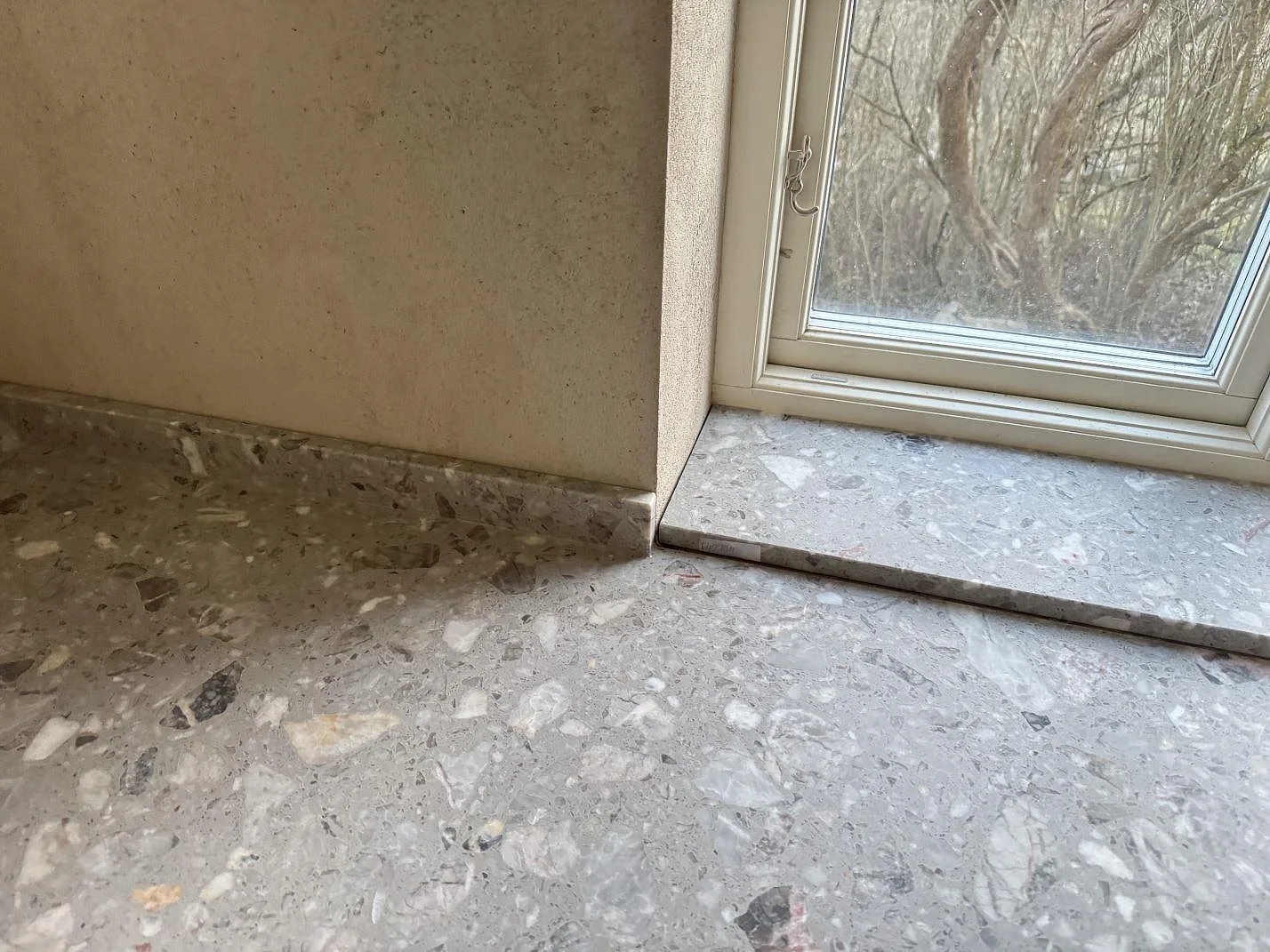 Detalj av matt Terrazzo Fior Di Pesco med kort stänkkant och fönsterbänk i Sankt olof.