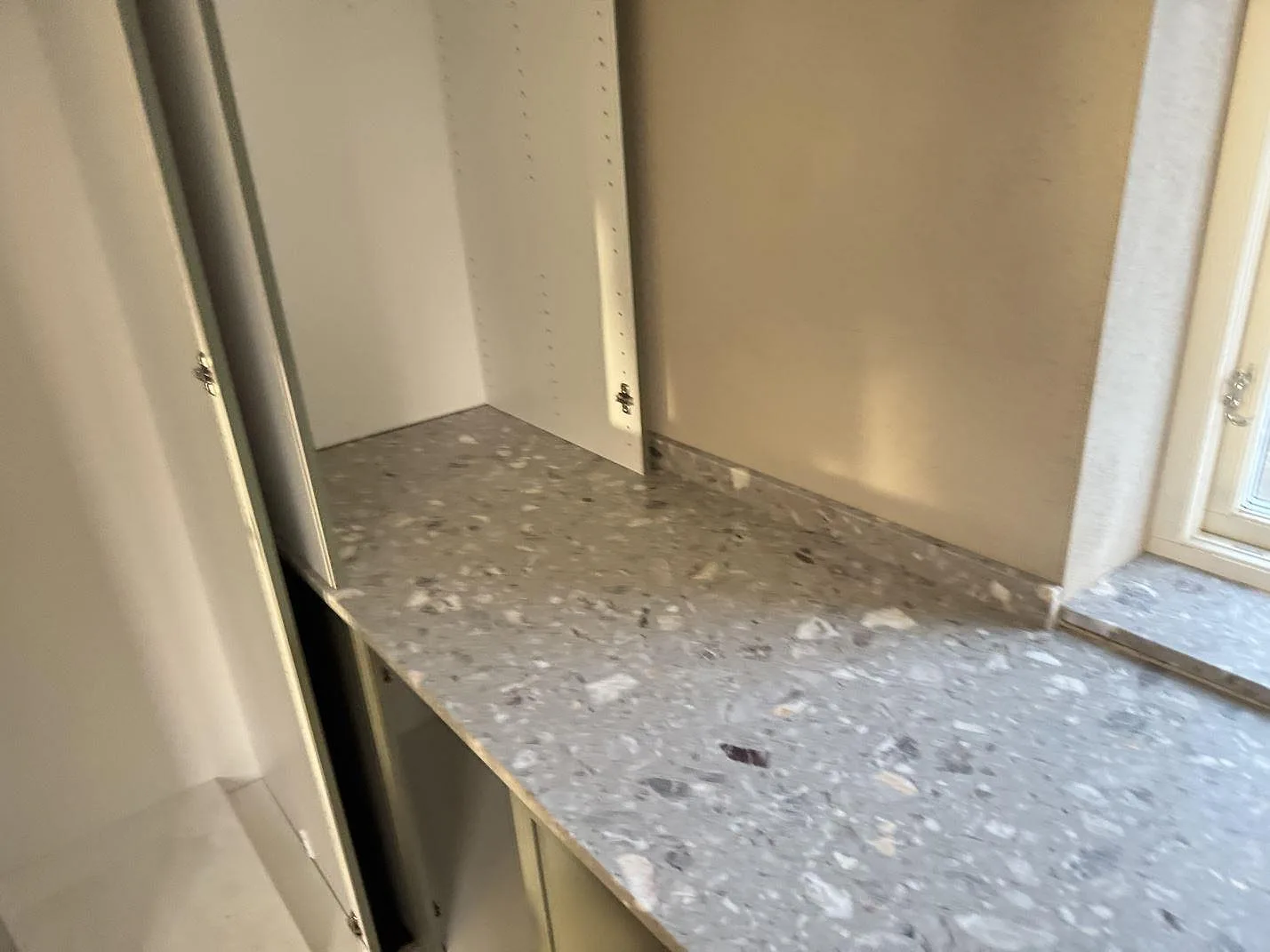 Installerad bänkskiva i matt Terrazzo Fior Di Pesco mellan öppna köksstommar och fönster i Sankt olof.