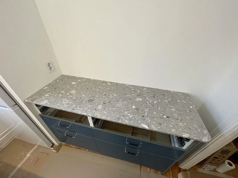 Separat bänkskiva i matt Terrazzo Fior Di Pesco monterad på blå köksstommar i Stockholm.