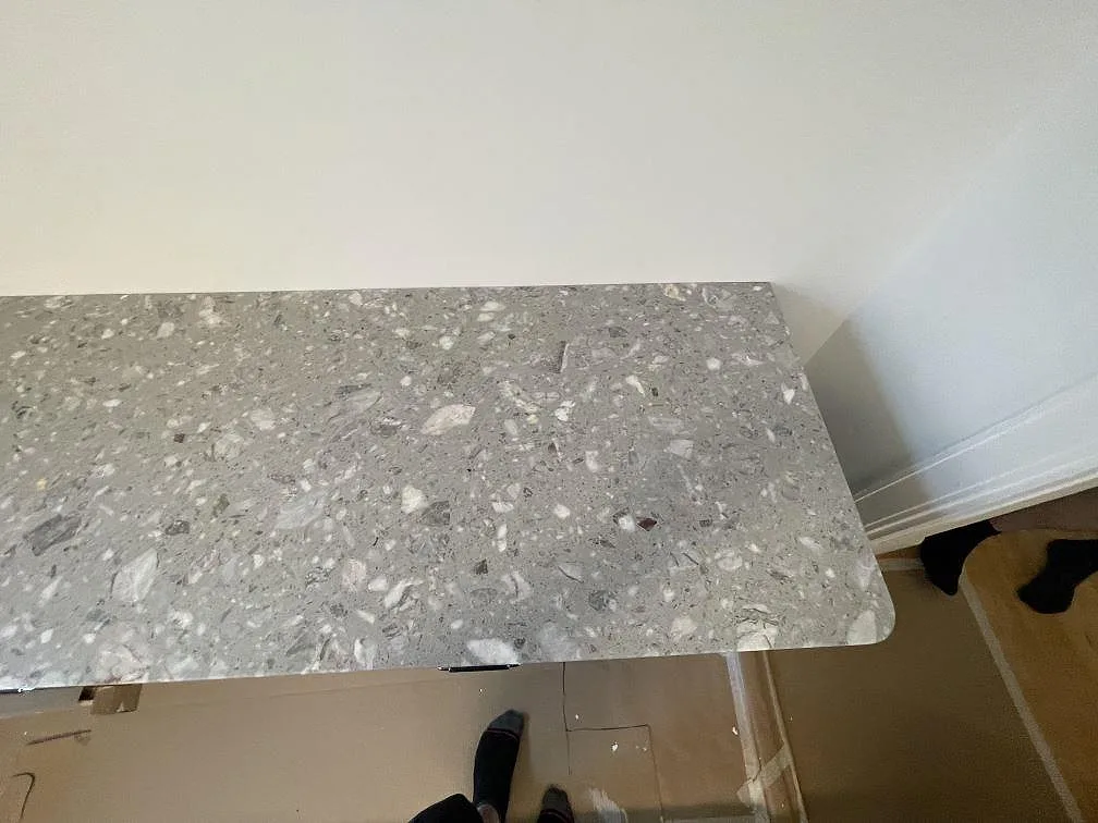 Ytnärbild av grå Terrazzo Fior Di Pesco med ljusa stenfragment och matt finish i ett kök i Stockholm.
