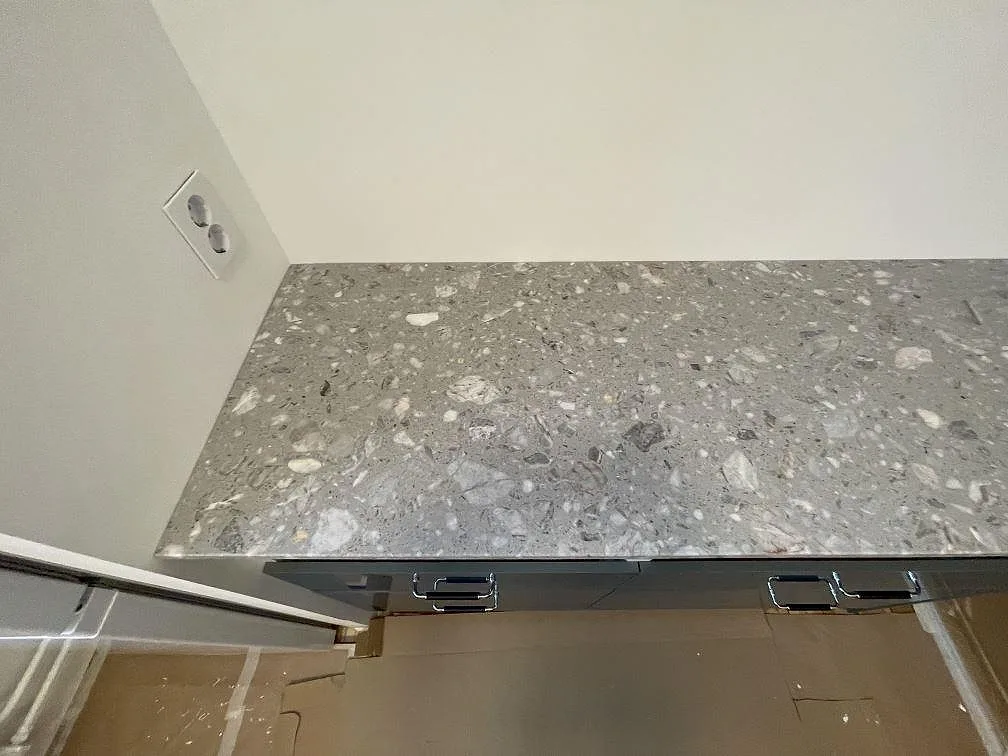 Rak frontvy av matt Terrazzo Fior Di Pesco som bänkskiva på underskåp i ett kök i Stockholm.