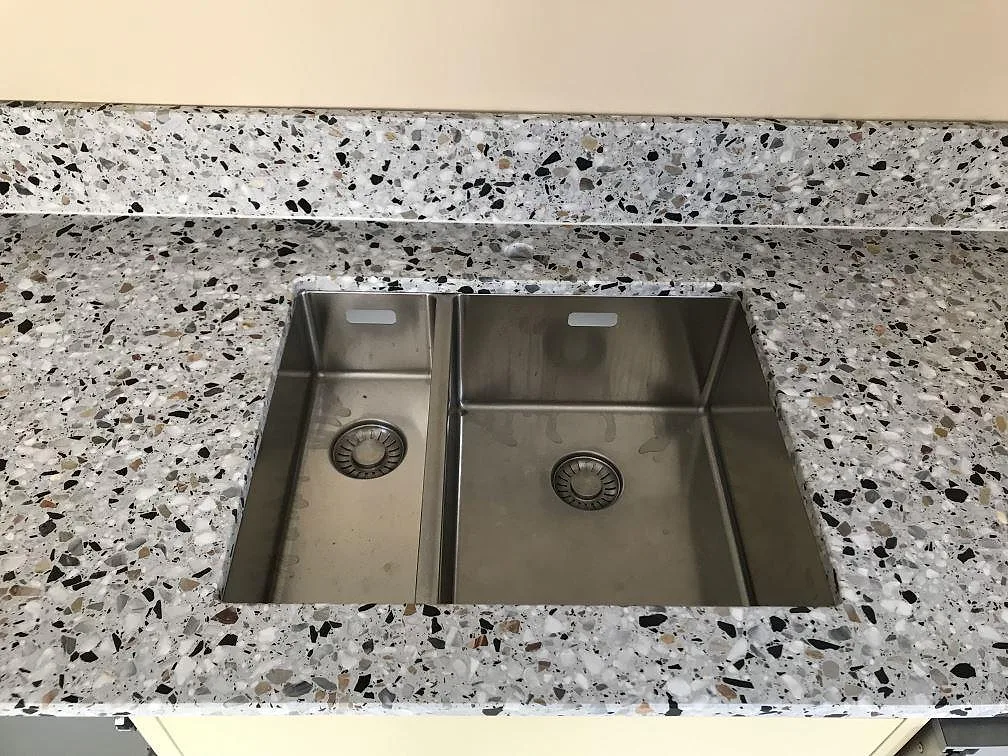 Underlimmad rostfri diskho infälld i terrazzobänkskiva i Terrazzo GV i ett kök i Göteborg.