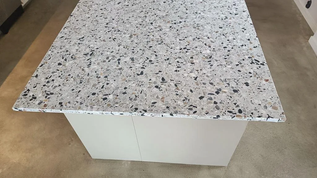 Närbild av köksö i Terrazzo GV, Matt, med ljus terrazzo och mörk ballast i ett kök i Malmö.