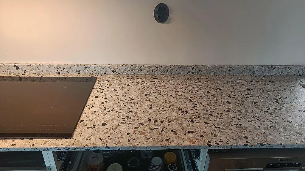 Rak bänkrad i Terrazzo GV, Matt, med stänkkant, svart häll och vit köksstomme i Malmö.