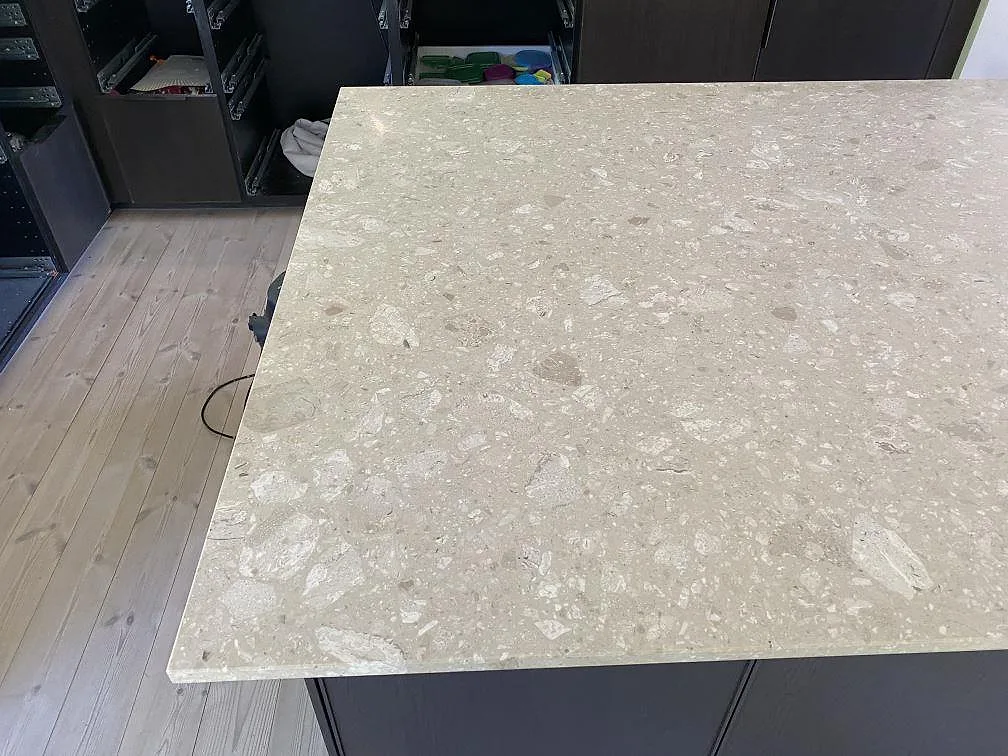Stor matt bänkskiva i Terrazzo Perlato Royal monterad på mörka köksstommar i Espergærde.