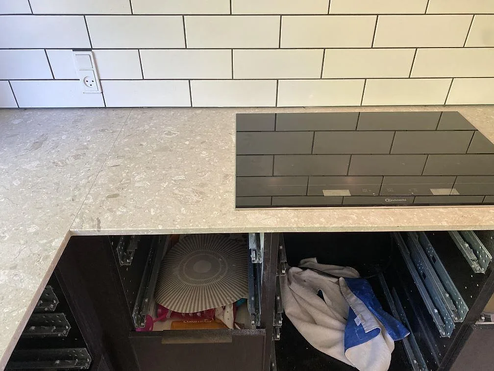 Matt köksbänkskiva i Terrazzo Perlato Royal med svart induktionshäll och vitt kakel i Espergærde.