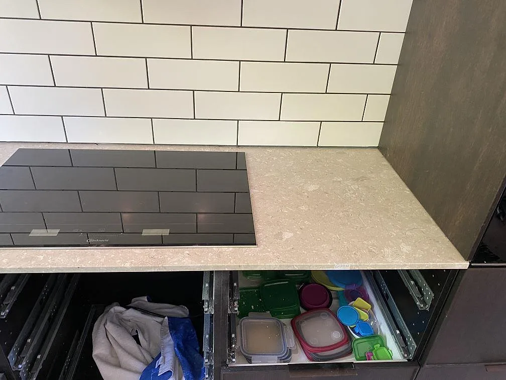 Terrazzo Perlato Royal som matt köksbänkskiva med svart induktionshäll och mörka köksstommar i Espergærde.