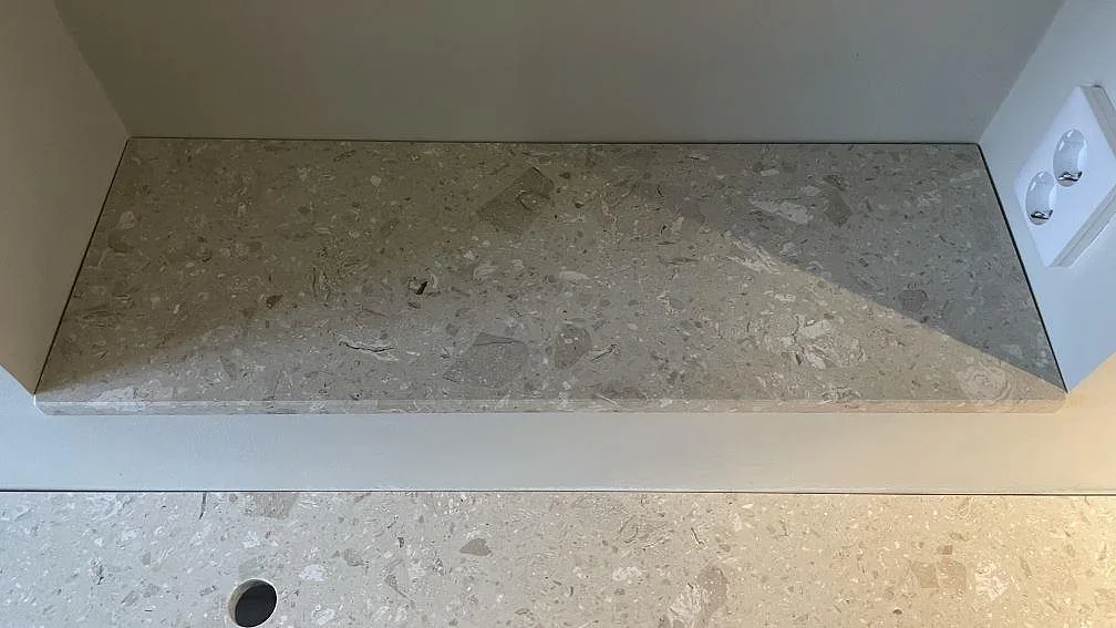 Bänkskiva i Terrazzo Perlato Royal monterad i en nisch med synlig stenkant och pale aggregat i Göteborg.