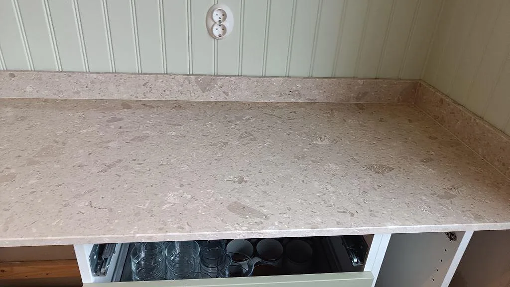 Lång bänkyta i matt Terrazzo Perlato Royal med beige stenfragment och matchande stänkkant i Göteborg.