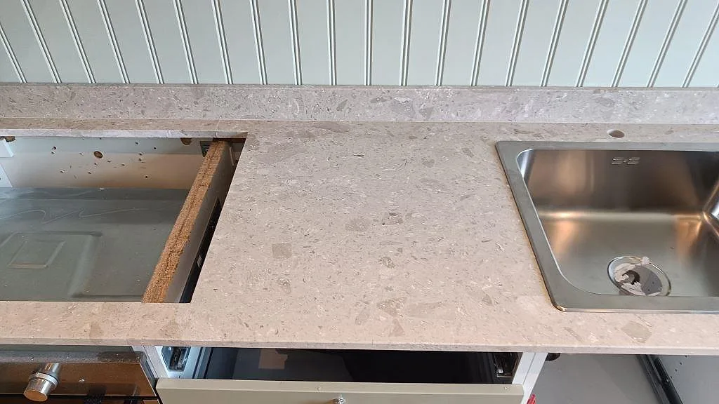 Köksbänkskiva i matt Terrazzo Perlato Royal mellan diskho och spisöppning med matchande stänkkant i Göteborg.