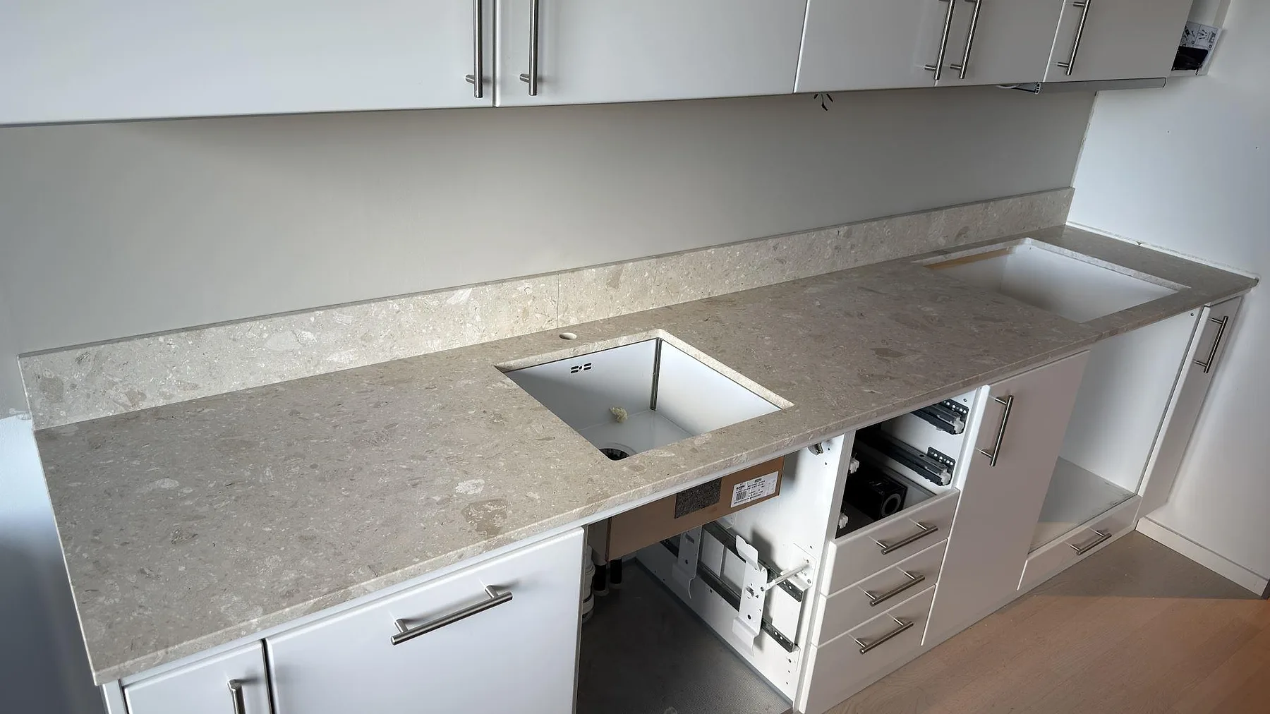 Matt Terrazzo Perlato Royal som köksbänkskiva med underlimmad diskho och uppvikt stänkskydd längs väggen i ett kök i Hägersten.