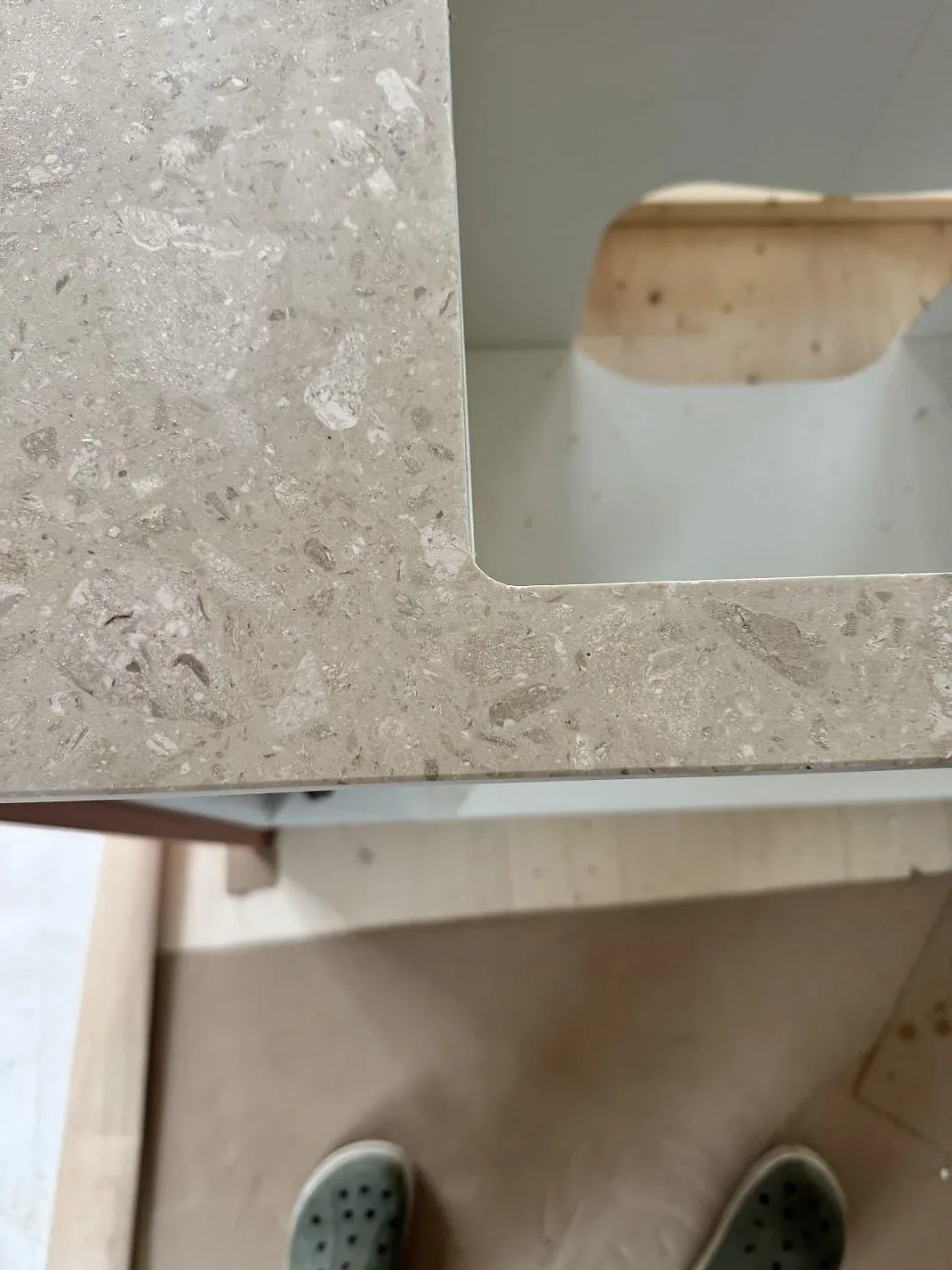 Detalj av hörn och urtag i matt Terrazzo Perlato Royal på köksbänkskiva under montering i Hindås.