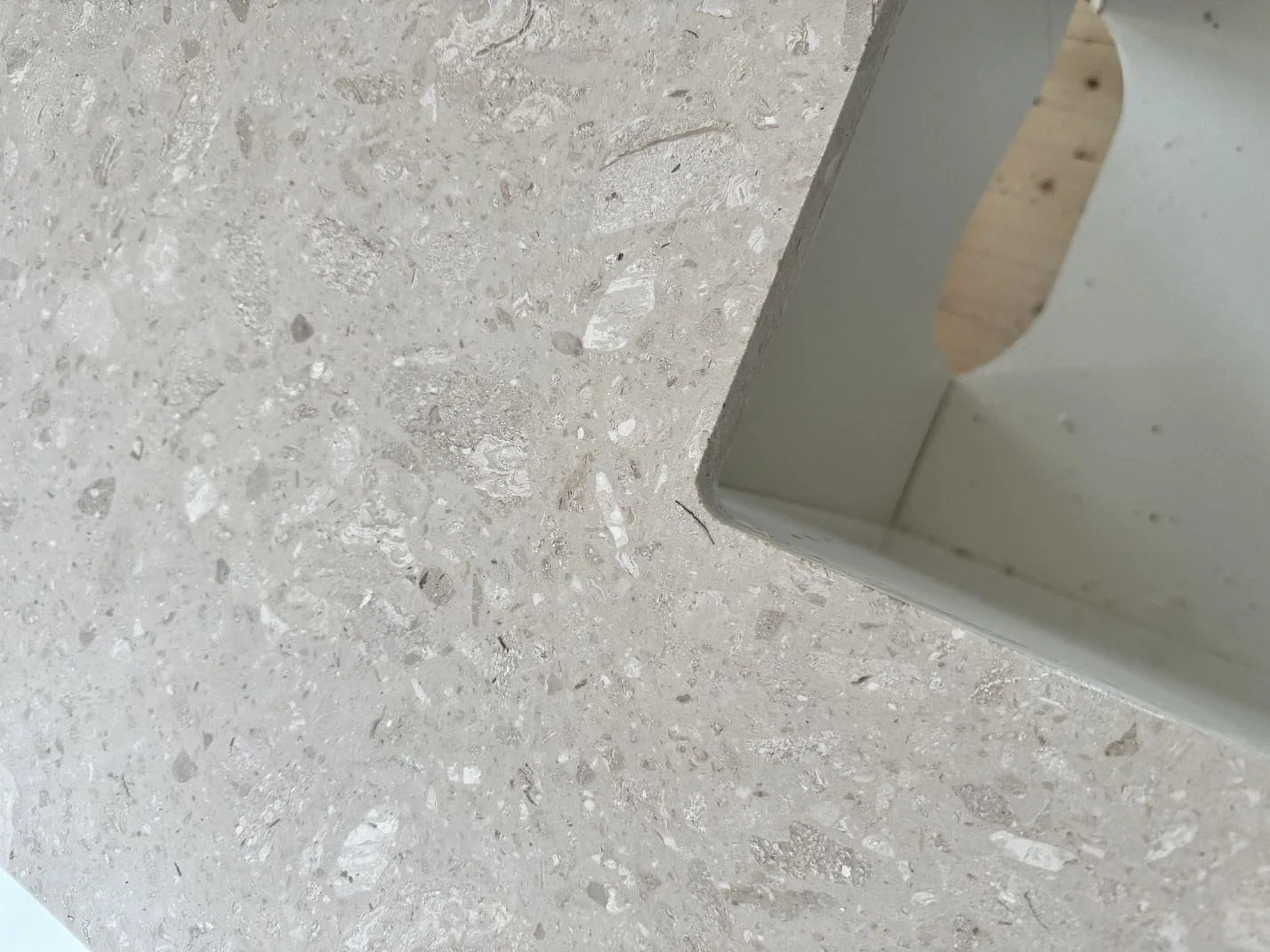 Närbild av matt Terrazzo Perlato Royal med ljus ballast och urtag i köksbänkskiva i Hindås.