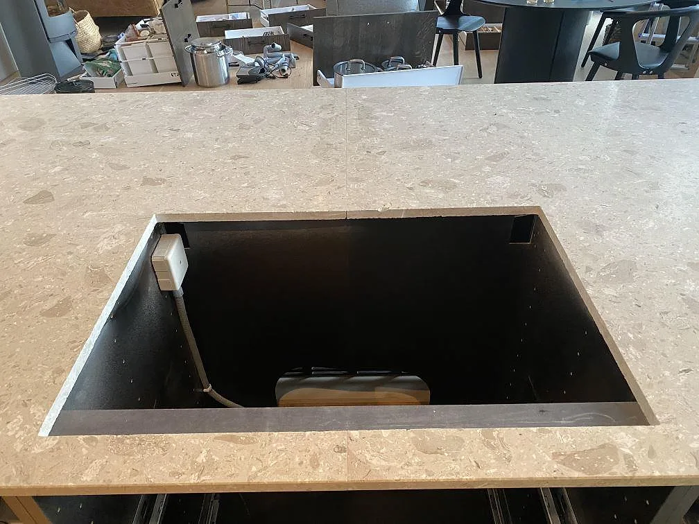 Köksö i Terrazzo Perlato Royal med urtag för infälld häll, matt yta med marmorflisor, i ett kök i Höllviken.