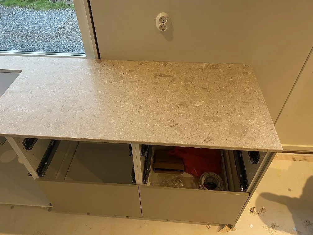 Lång köksbänkskiva i Terrazzo Perlato Royal, matt, med synliga stenfragment och öppna stommar under montering i Kungsbacka.