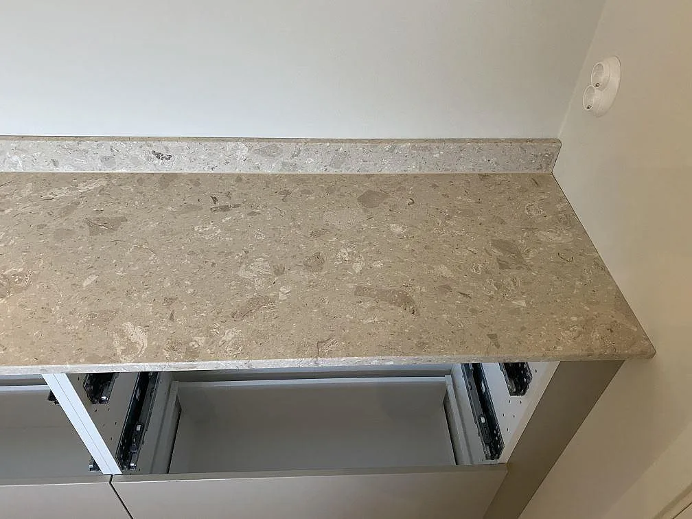 Närbild på matt bänkskiva och låg stänkkant i Terrazzo Perlato Royal i kök i Kungsbacka.