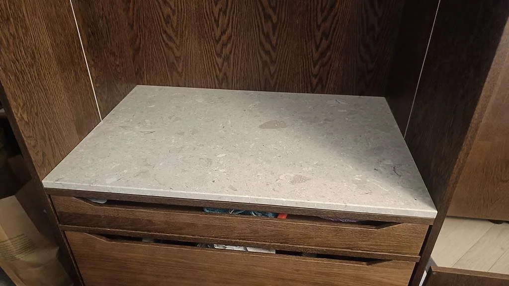Installerad bänkskiva i matt Terrazzo Perlato Royal på mörk träinredning, med tydlig beige terrazzo-yta i Limhamn.