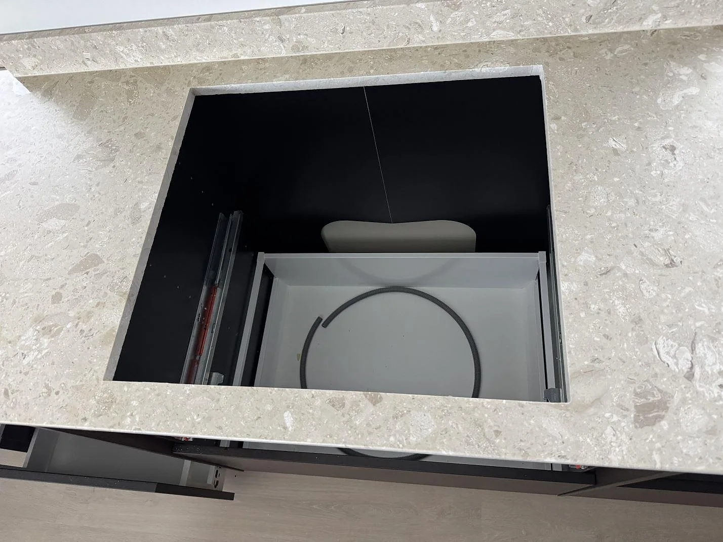 Detalj av rektangulär öppning i köksbänkskiva av matt Terrazzo Perlato Royal med låg stänkkant i Löddeköpinge.