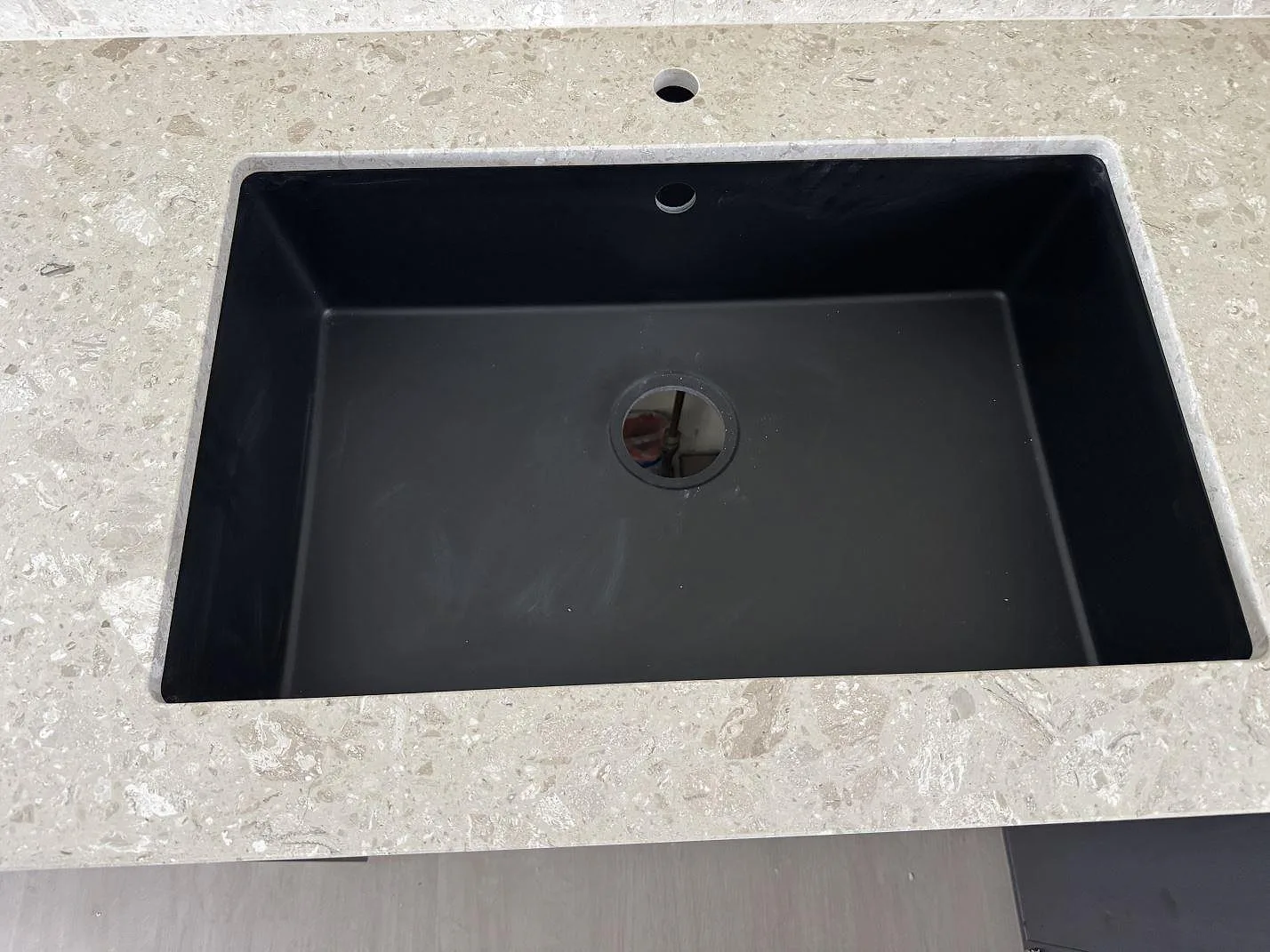 Detalj av svart diskho i köksbänkskiva av matt Terrazzo Perlato Royal i Löddeköpinge.