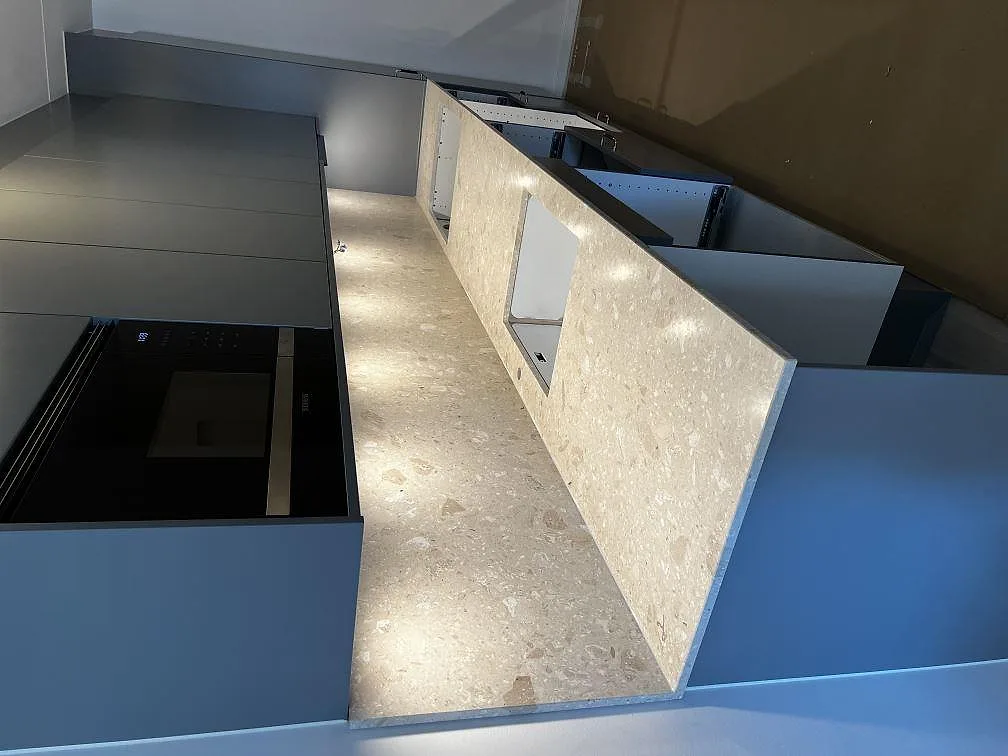 Köksbänkskiva och köksö i ljus Terrazzo Perlato Royal, matt yta, med urtag för diskho och induktionshäll i ett kök under montering i Malmö.