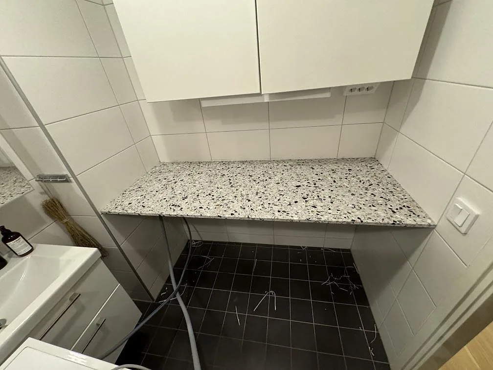 Badrumsbänkskiva i svartvit Terrazzo GV, matt, monterad i ett badrum i Malmö.