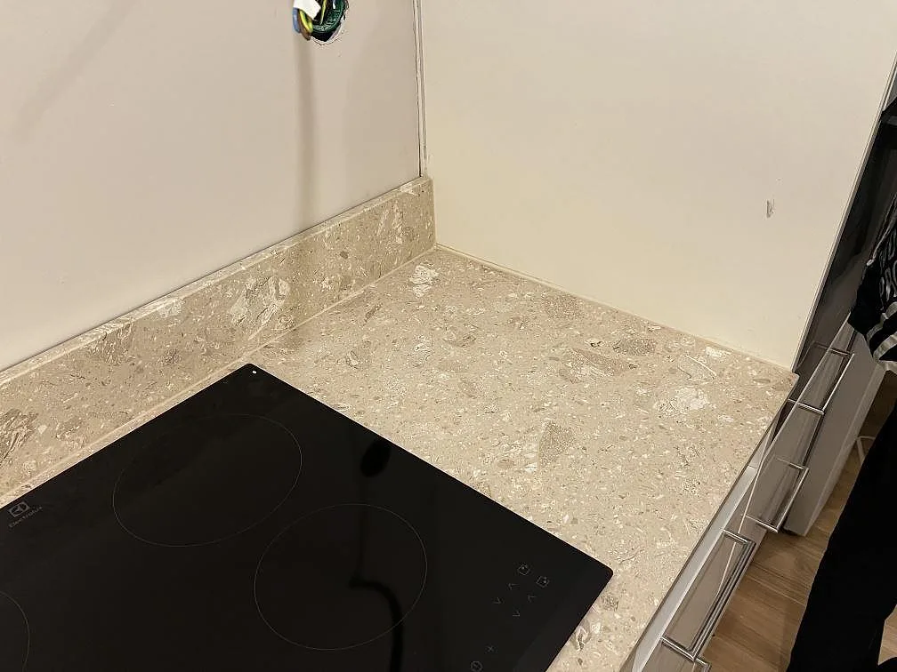 Detalj av matt Terrazzo Perlato Royal vid induktionshällen och stänkkanten i ett kök i Malmö.