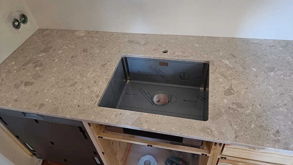 Närbild på diskhozonen i en matt Terrazzo Perlato Royal köksbänkskiva med tydlig beige terrazzoyta i Malmö.