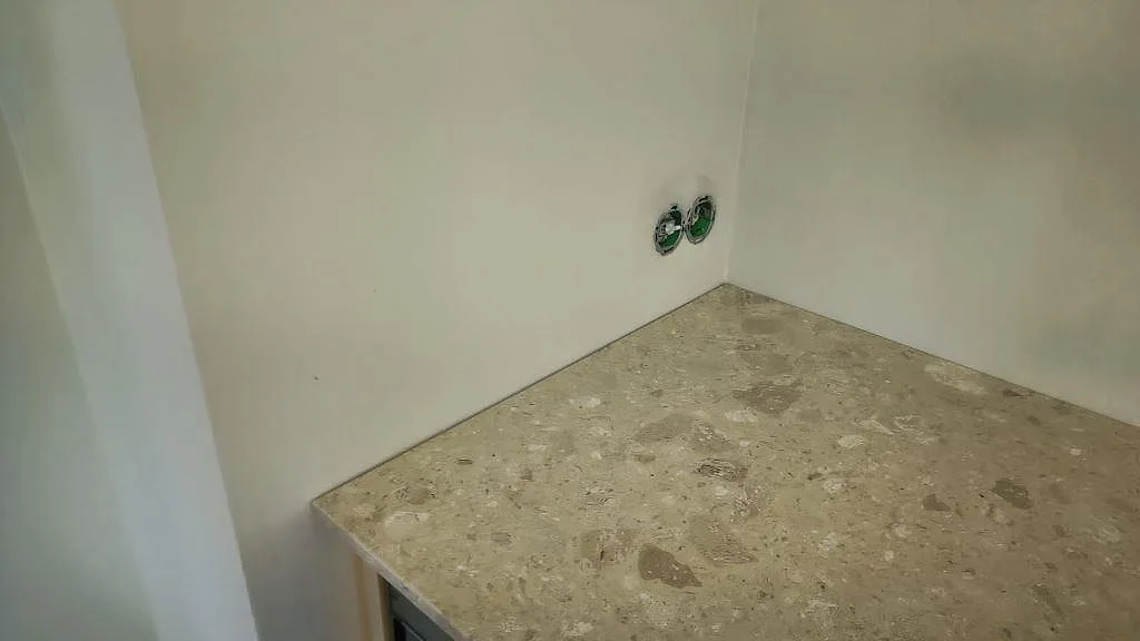 Hörndetalj av matt Terrazzo Perlato Royal bänkskiva med beige stenfragment i ett kök i Malmö.