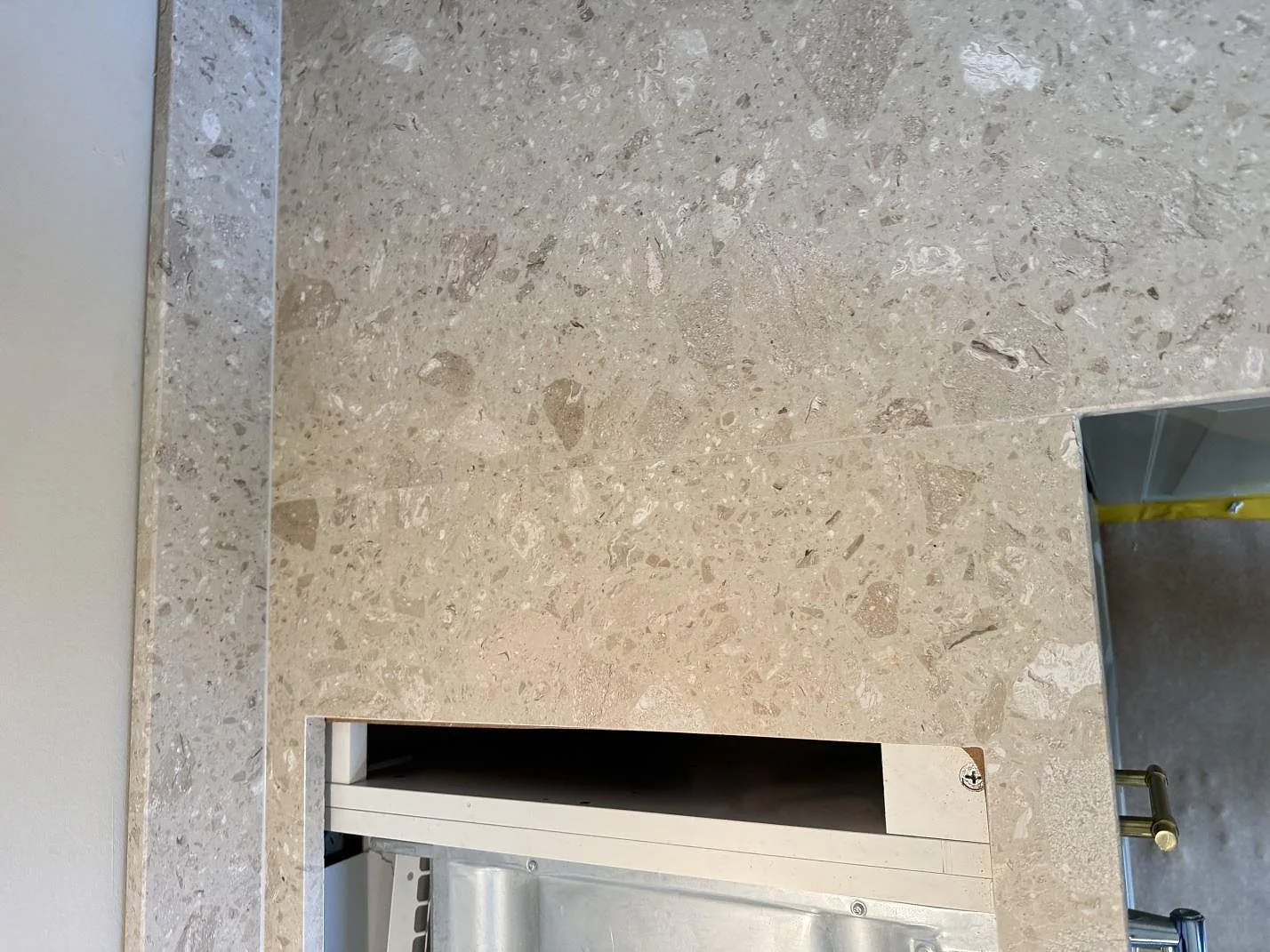Närbild av matt Terrazzo Perlato Royal som köksbänkskiva med stänkkant och utskärning vid spisen i Malmö.