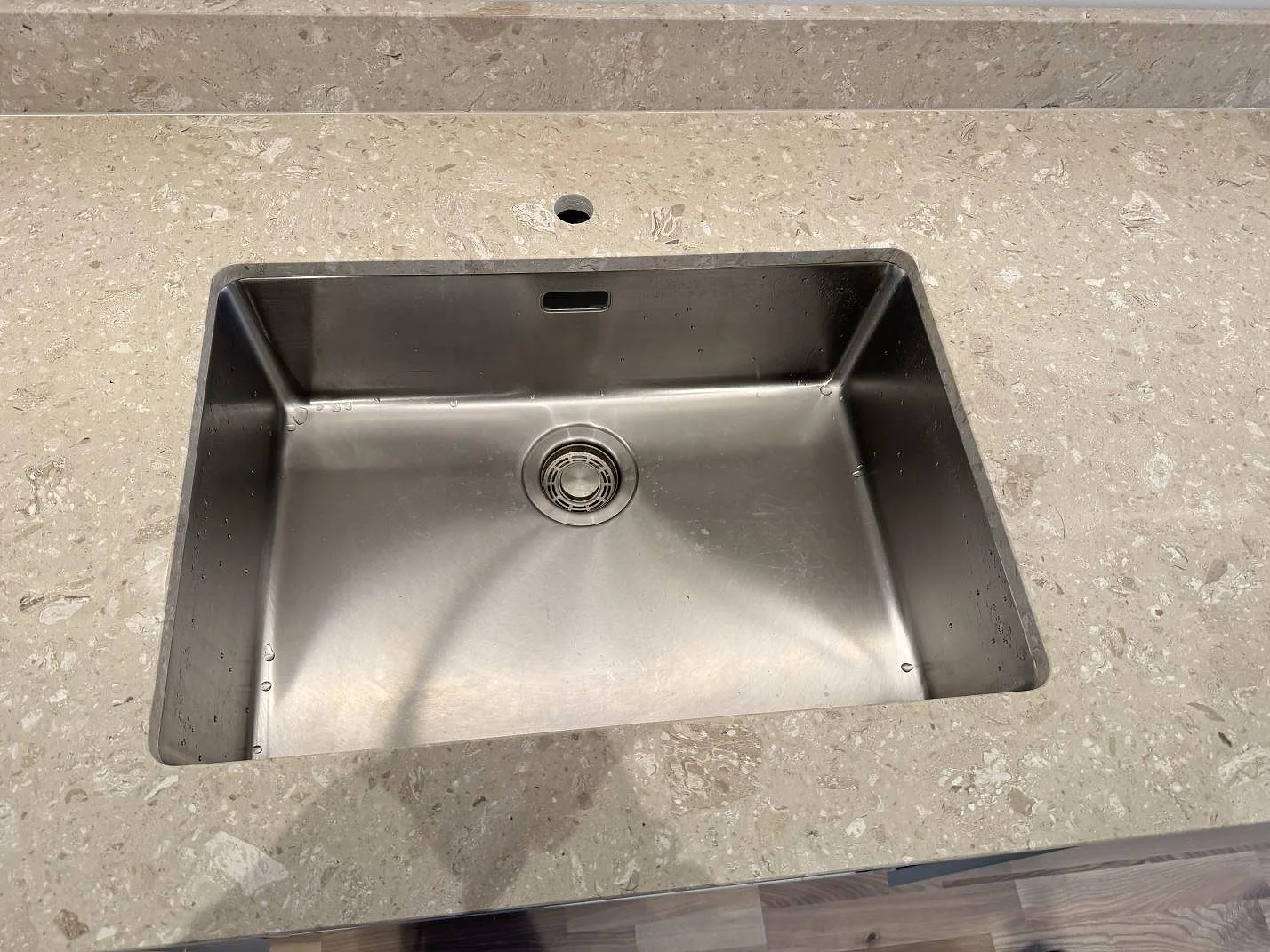 Närbild på underlimmad rostfri diskho i matt Terrazzo Perlato Royal med synlig terrazzo runt urtaget i Malmö.