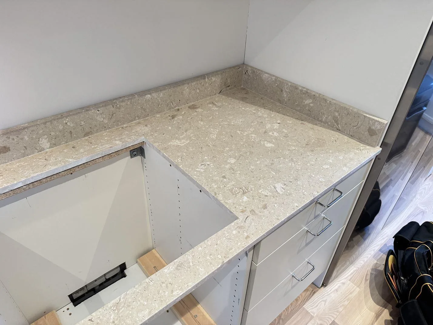 Höger del av köksbänkskiva i matt Terrazzo Perlato Royal med hällöppning, stänkkant och underskåp i Malmö.