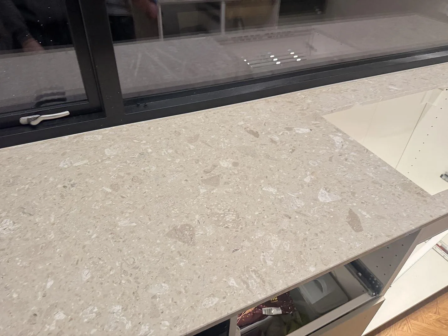 Matt köksbänkskiva i Terrazzo Perlato Royal med rektangulär urtagning och fönster bakom i Odense SV.