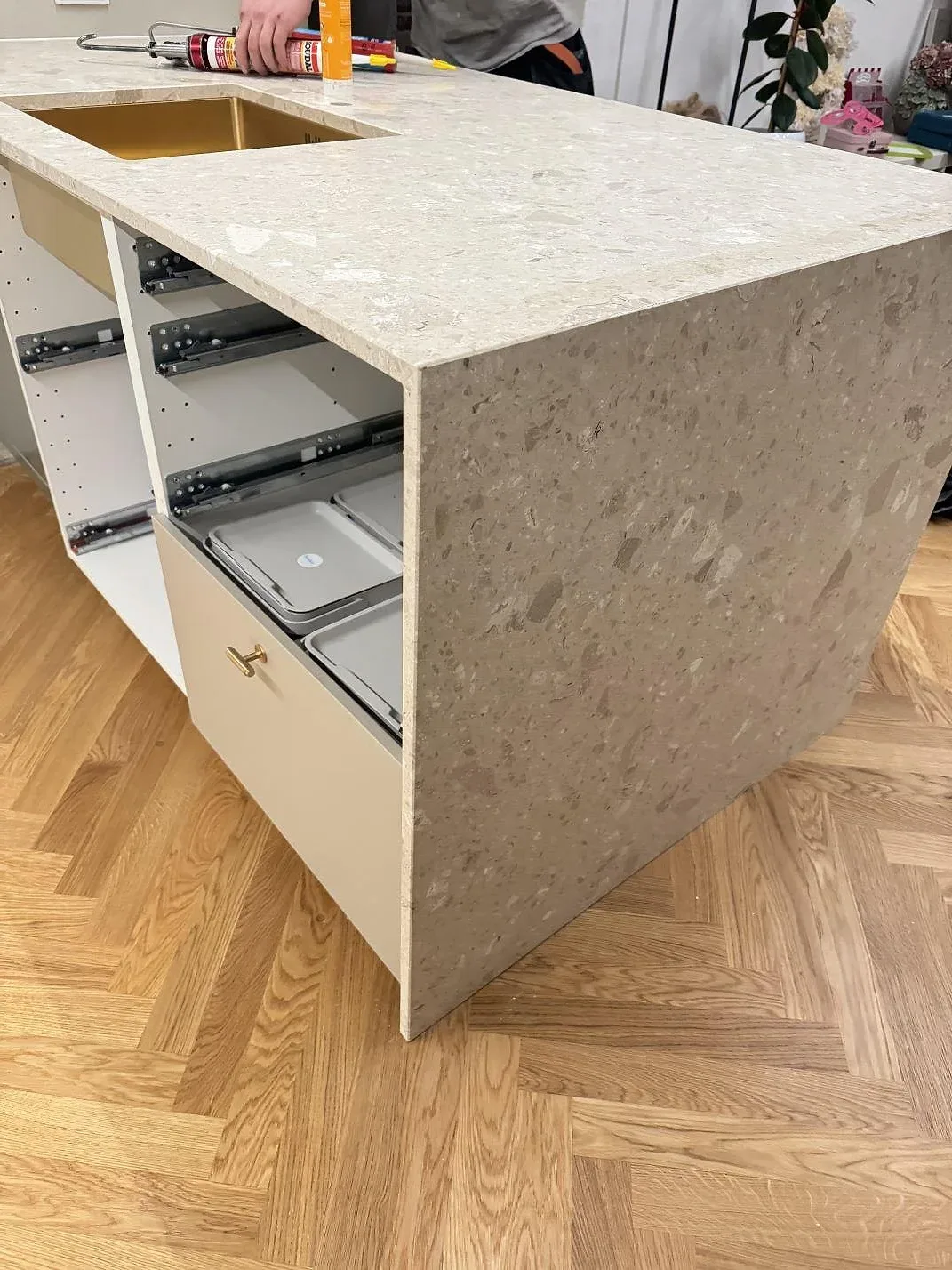Bred vy av matt köksbänkskiva i Terrazzo Perlato Royal på köksstommar under montering i Odense SV.