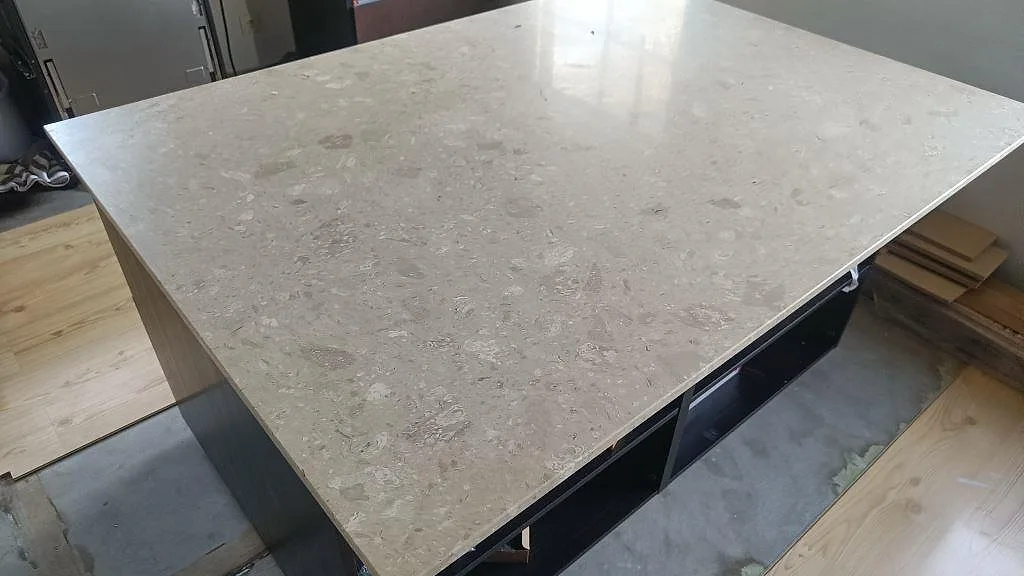 Närbild på stor köksö i matt Terrazzo Perlato Royal med beige terrazzo och synliga stenfragment i Skurup.