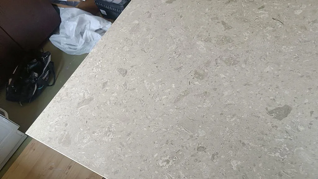 Närbild på monterad köksö i matt Terrazzo Perlato Royal under installation med verktyg vid sidan i Skurup.