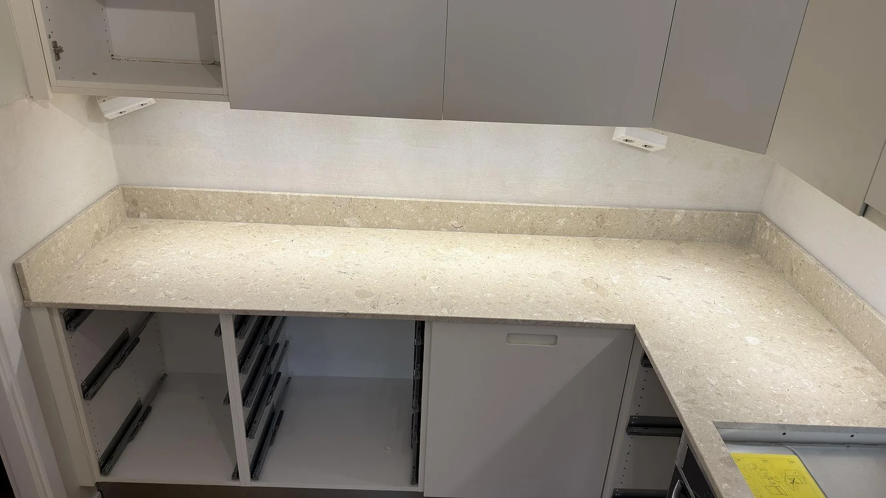 Ljus terrazzo bänkskiva i Terrazzo Perlato Royal, matt, med uppvikt stänkkant och synlig stenstruktur i Solna.