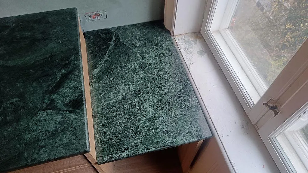 Polerad Verde Guatemala marmor som liten sidoyta vid fönster intill köksbänken i Frederiksberg.