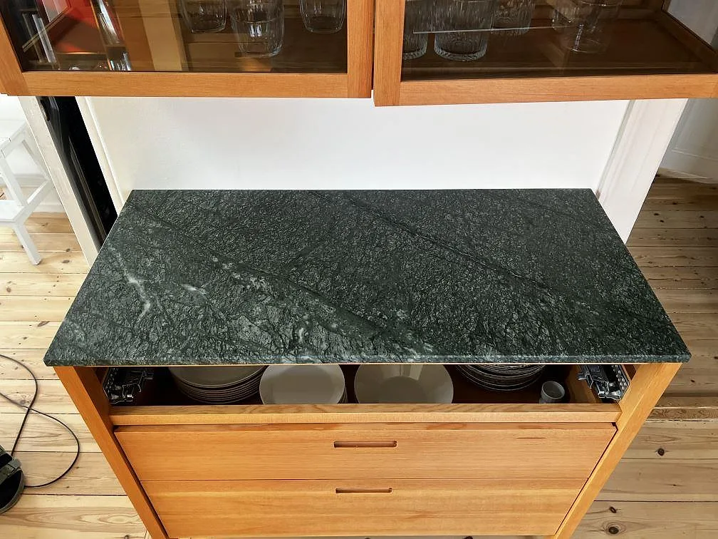 Närbild av 20 mm matt Verde Guatemala marmor som köksbänkskiva på träinredning i Fredriksberg.