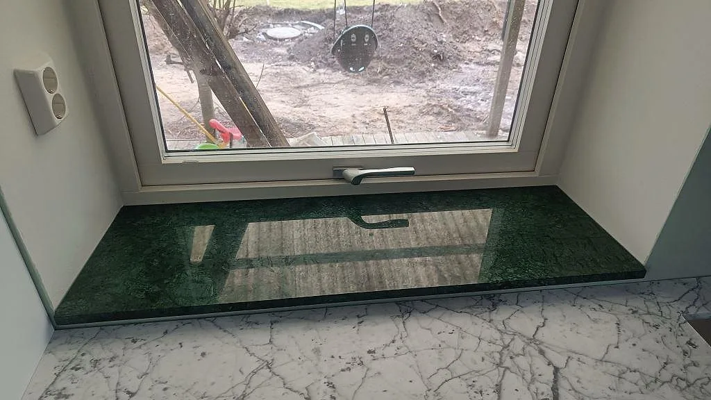 Fönsterbänk i grön Verde Guatemala marmor, polerad, monterad vid fönster i ett hem i Tygelsjö.