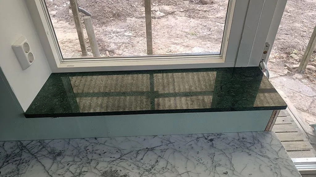 Polerad fönsterbänk i Verde Guatemala marmor med djupgrön ådring vid altandörr i Tygelsjö.