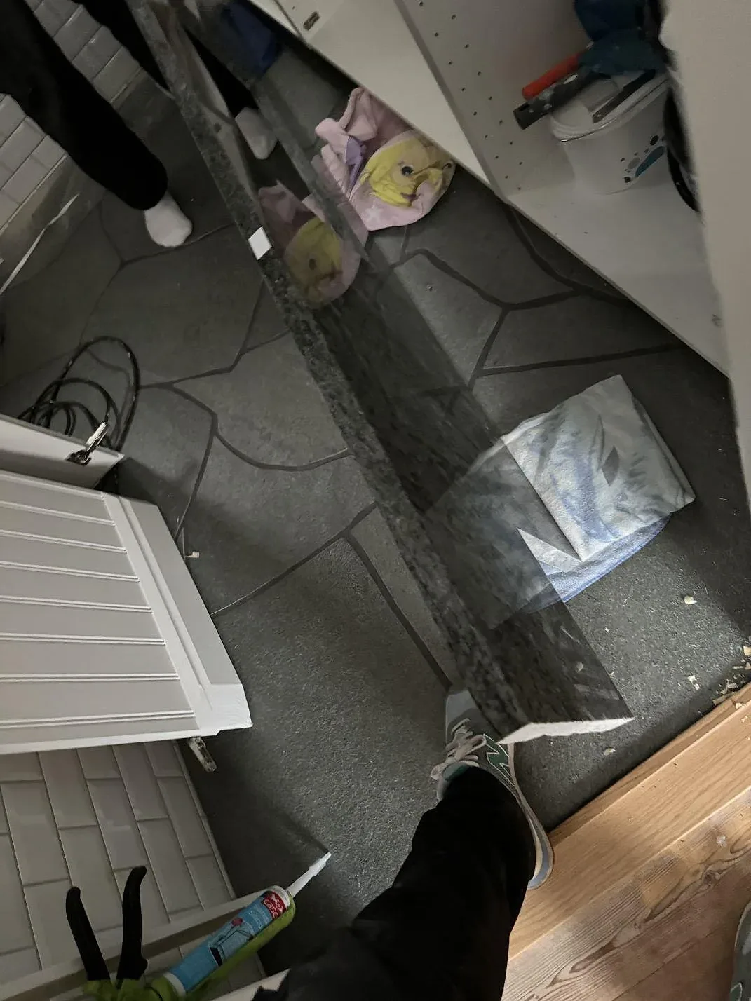 Polerad köksbänkskiva i Verde Savana granit under montering vid vita skåp och radiator i Bara.