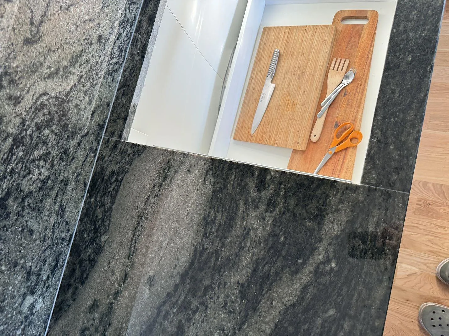 Detalj av polerad Verde Savana granit runt hällöppning och stänkskydd under montering i Bunkeflostrand.