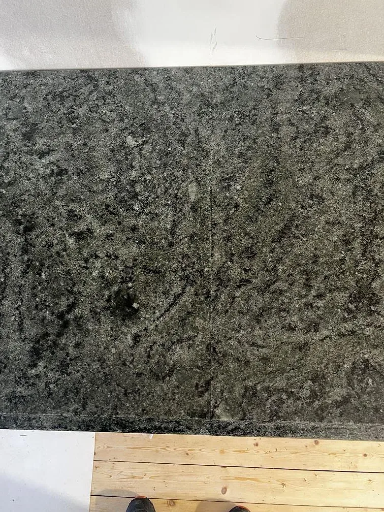 Topvy av installerad köksbänkskiva i Verde Savana granit, polerad, med mörkgrön och grå struktur i Degeberga.