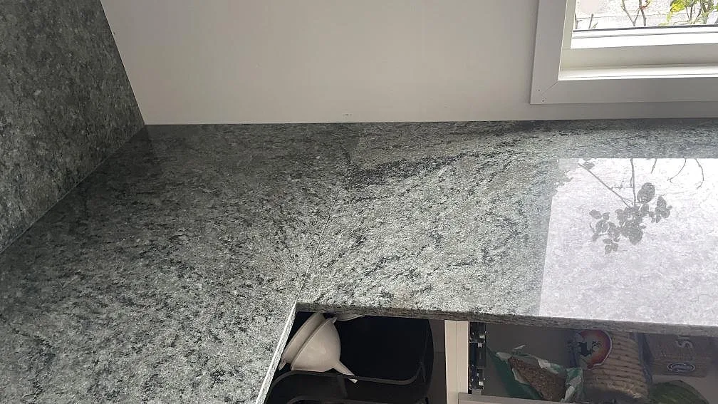 Polerad Verde Savana granit under fönster med blank yta och grönsvart ådring i ett kök i Malmö.