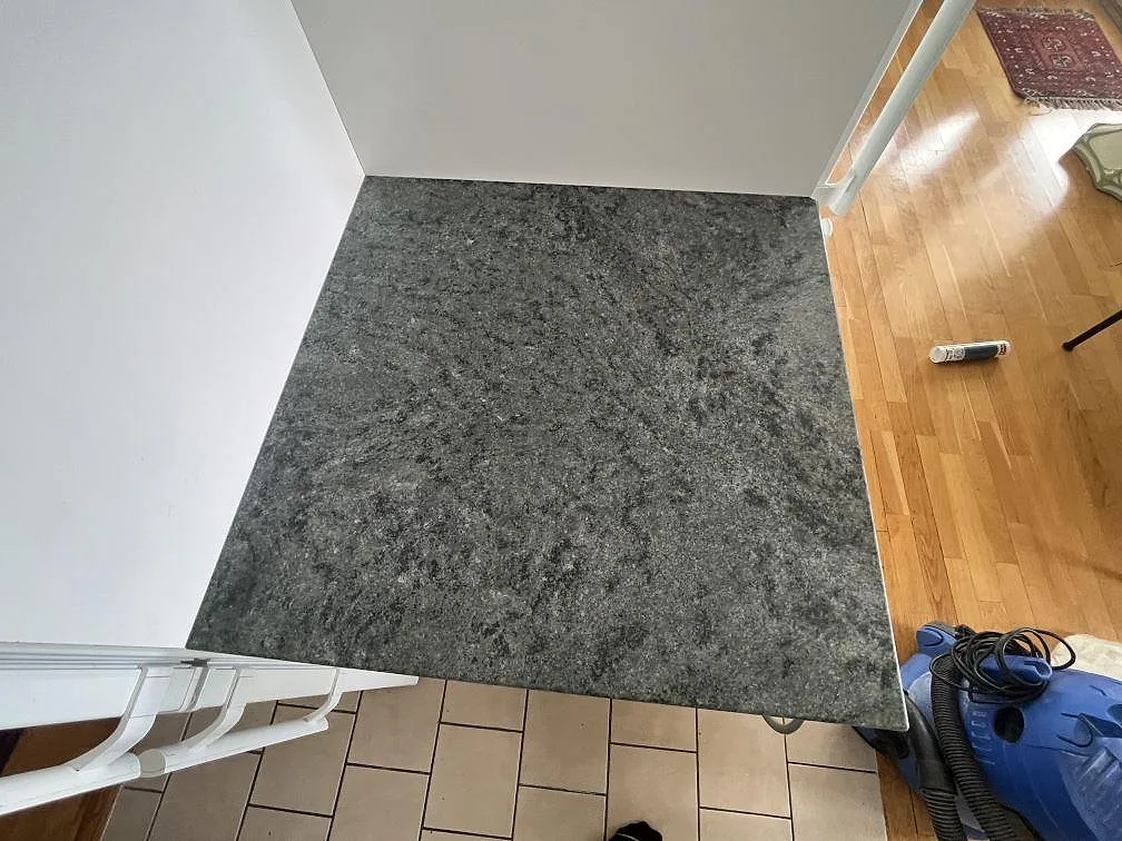 Närbild av matt Verde Savana granitbänkskiva med tät mörkgrön och grå ådring i en köksinstallation i Stockholm.
