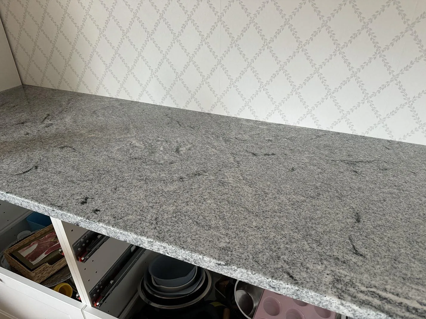 Närbild av polerad Viscont White granitbänkskiva med grå ådring och rak framkant i ett kök i Bjärred.