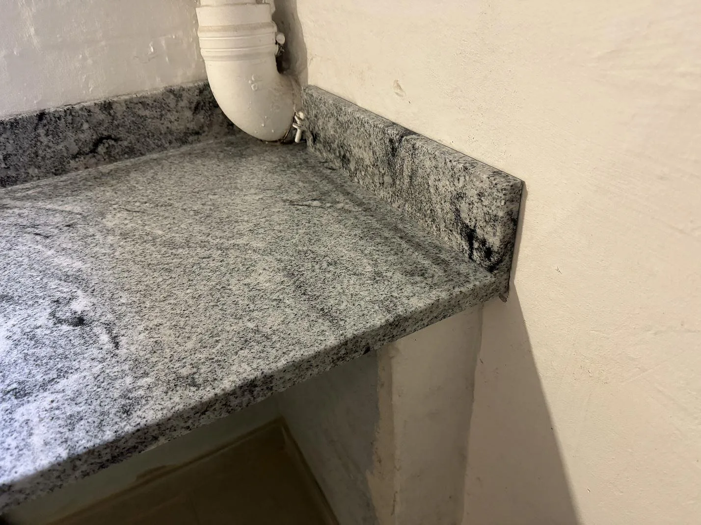 Sidovy av polerad bänkskiva i Viscont White granit med tjock framkant och uppvikt stenkant i Frederiksberg.