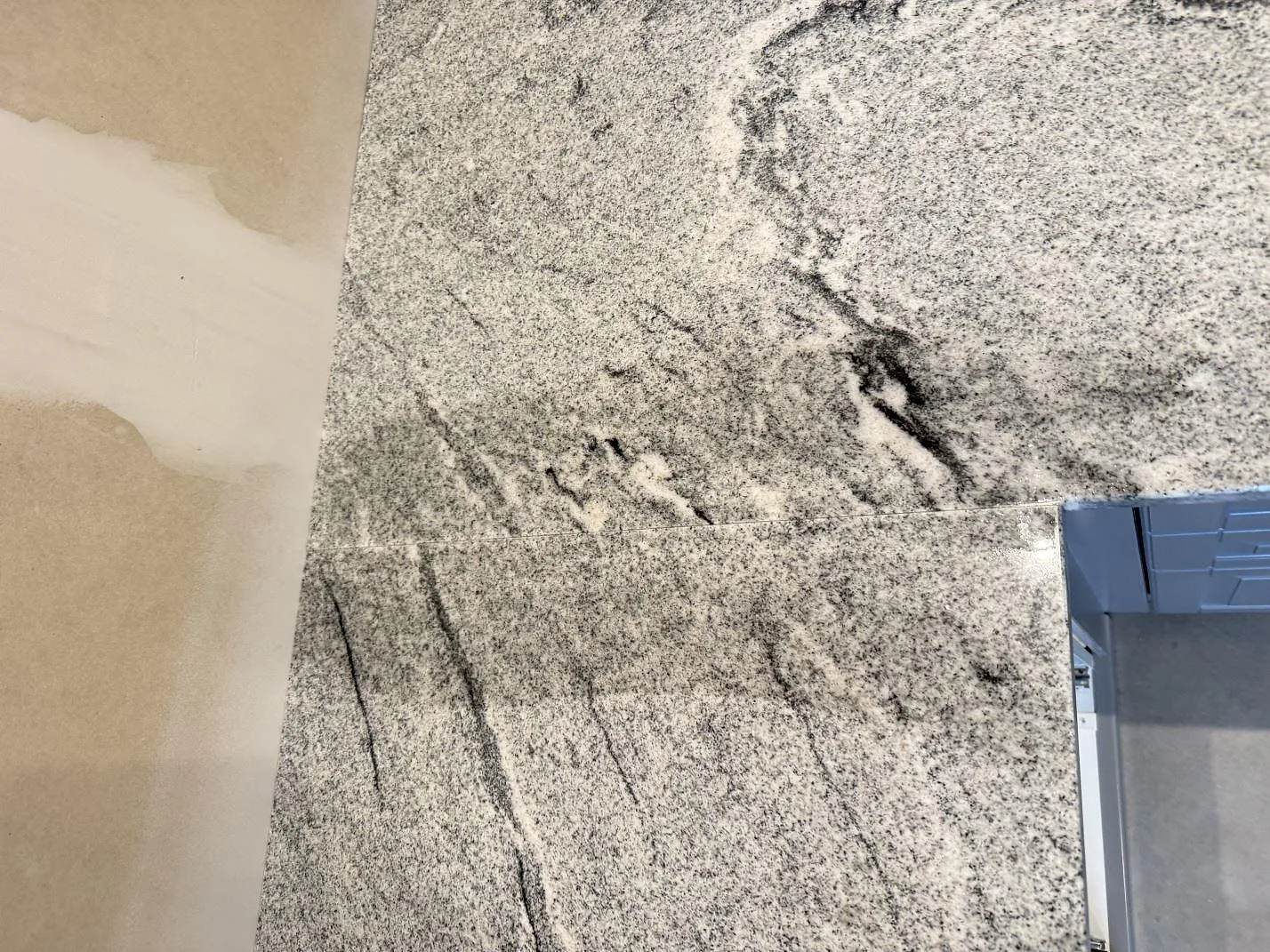 Närbild av polerad Viscont White granit med grå och svarta stråk på köksbänk i Kävlinge.